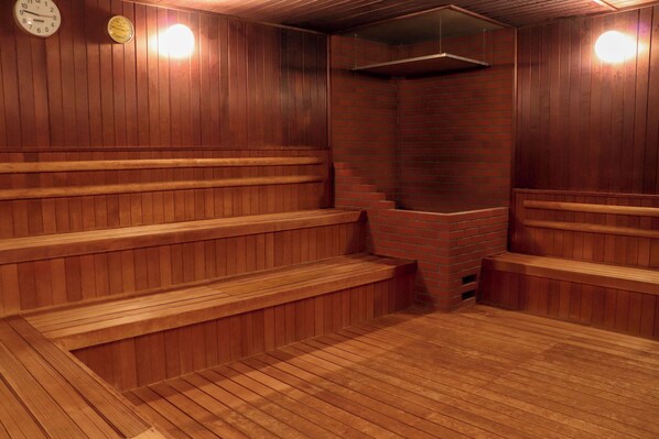 A sauna with wooden benches and a brick wall. - Premier Hotel Tsubaki Sapporo (Sapporo)