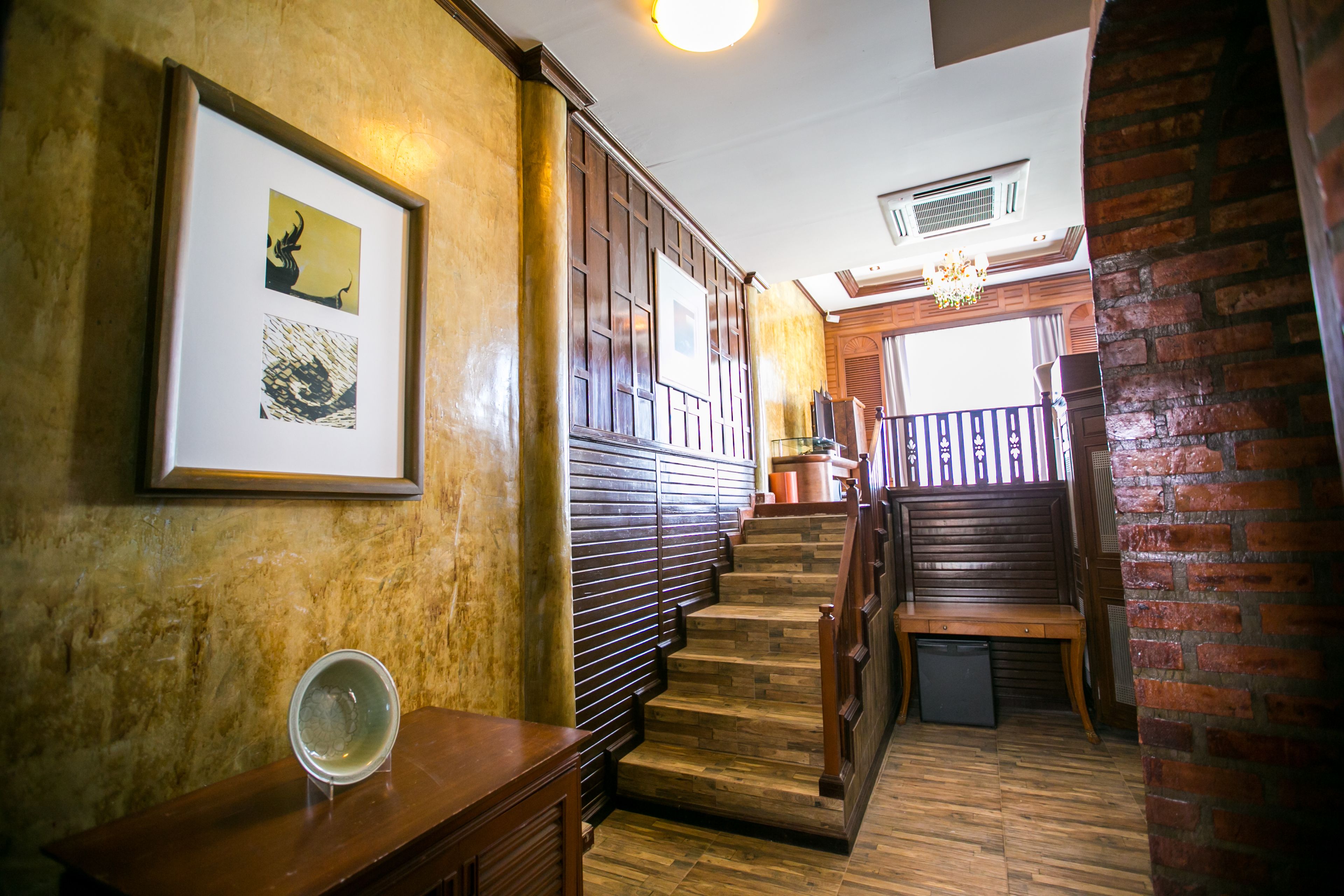 A staircase with wooden steps and a bench at the top, leading to a balcony with a railing.