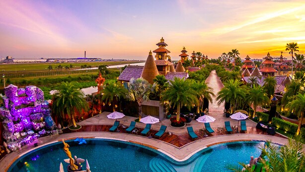 A resort with multiple swimming pools, palm trees, and traditional-style buildings. - Ammata Lanta Resort (Bang Phli)