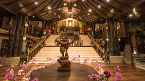 A grand staircase leading to a higher level, flanked by ornate statues and surrounded by a floral arrangement. - Ammata Lanta Resort (Bang Phli)
