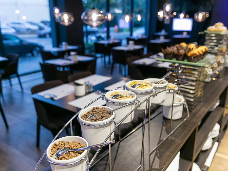 Una mesa de buffet con varios recipientes de comida y utensilios.