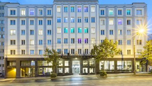 A multi-story hotel with a prominent "IMPERIAL" sign at the top. The building features a symmetrical facade with evenly spaced windows and a central entrance with glass doors. - Pytloun Grand Hotel Imperial (Liberec)