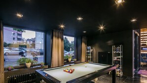 A pool table in a room with large windows, a radiator, and a bookshelf. - Pytloun Grand Hotel Imperial (Liberec)
