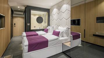Un dormitorio moderno con una cama grande, televisor integrado y un espejo.