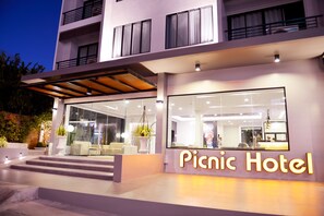 Un hotel moderno con facciata in vetro, un'area reception e una scalinata visibile che conduce all'ingresso.