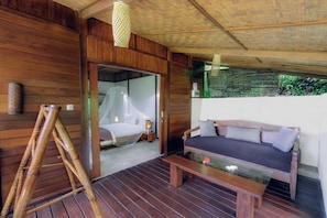 Una habitación de madera con una cama, un sofá y una mesa.