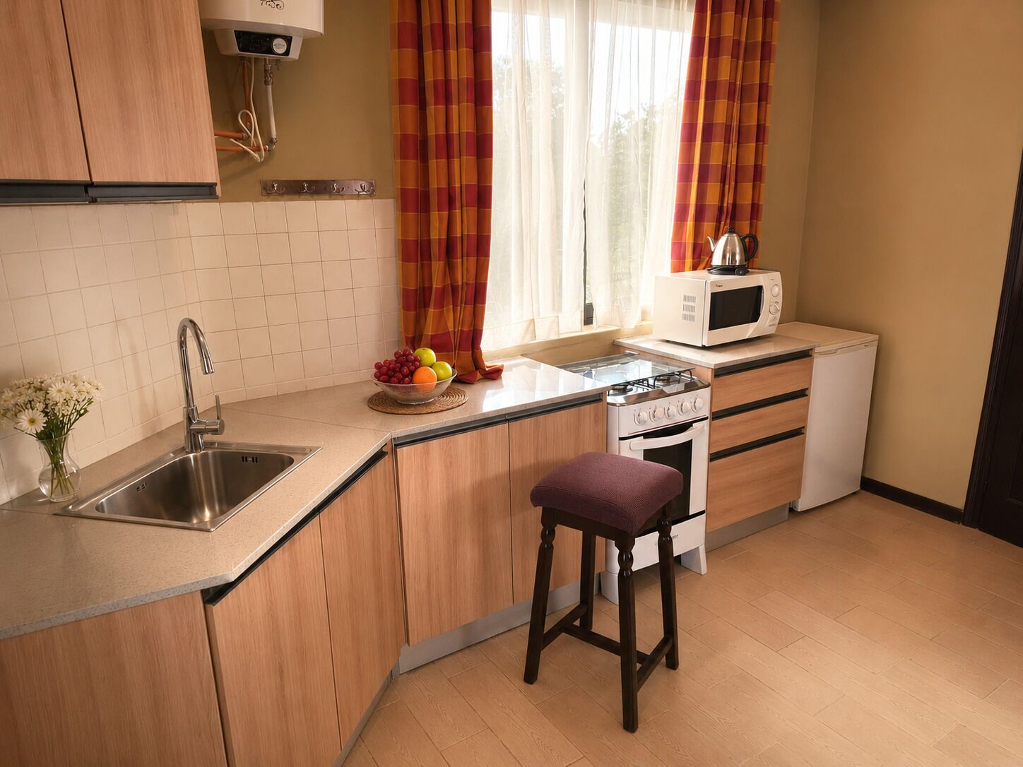 Cocina compacta con lavamanos, estufa y microondas.