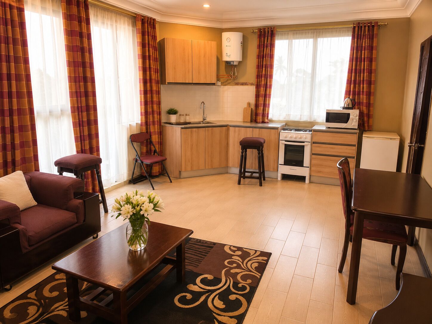 Un espacio habitable compacto con kitchenette, zona de comedor y sala de estar con sofá y mesa de centro.