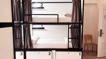 Habitación con literas, dos camas numeradas 1 y 2, y una silla pequeña.