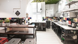Une cuisine moderne avec des meubles blancs, un îlot central et un plafond vert.