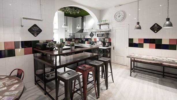 Une cuisine moderne dotée d’un îlot central, de tabourets de bar et d’une table à manger.