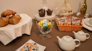 Un bufé de desayuno con croissants, caramelos de colores y juegos de té.