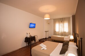 A hotel room with a bed, a desk, a chair, a television, and a window with curtains. - Baciami Ancora (Bari)