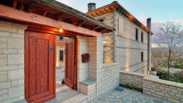 Un bâtiment en pierre doté de portes en bois et d’un escalier en pierre menant à l’entrée.