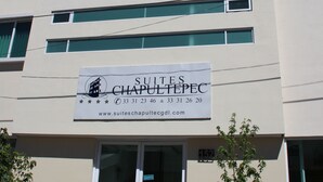 A building with a sign for 'Suites Chapultepec' and a website address. - Suites Chapultepec (Guadalajara)