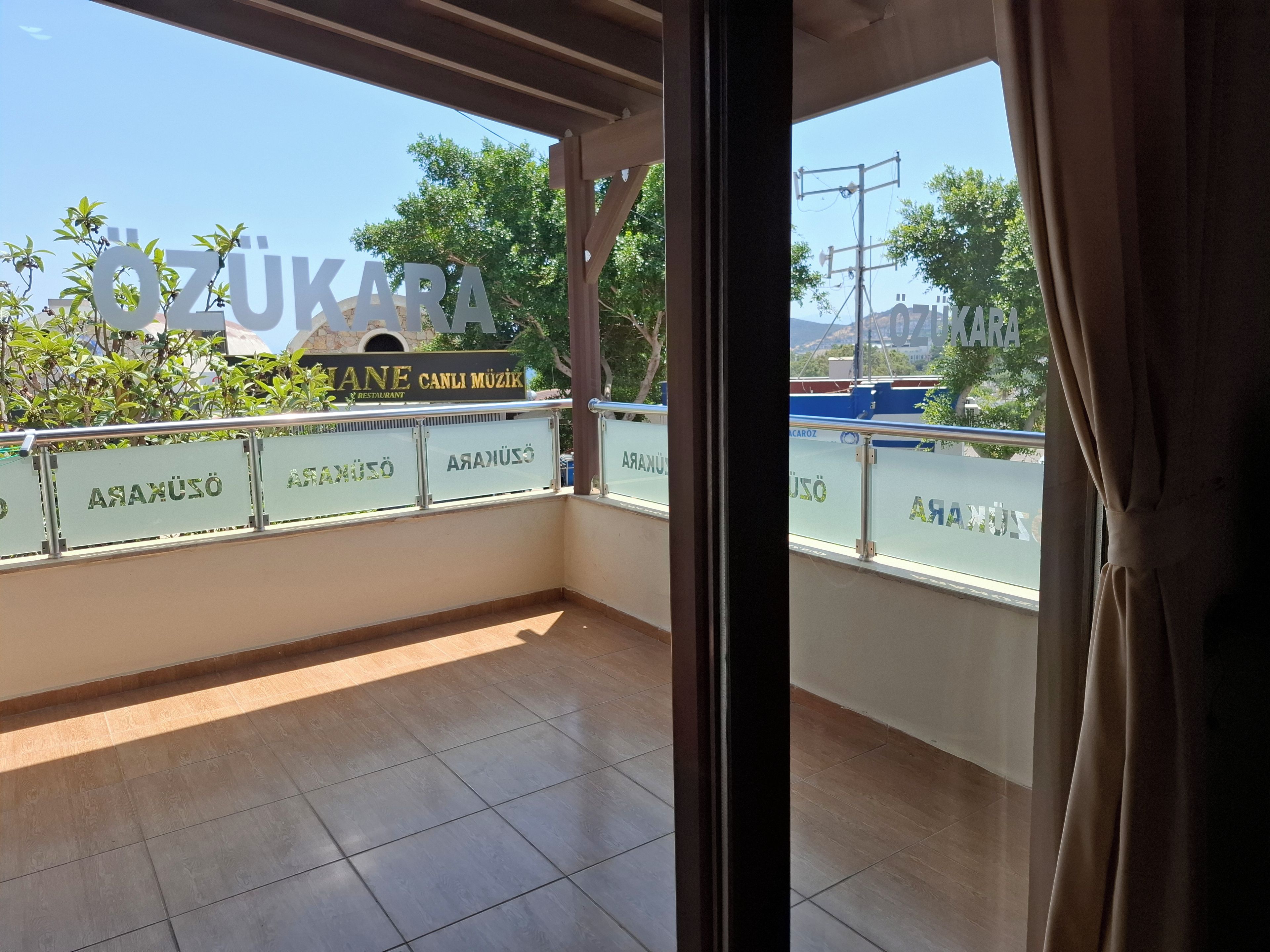 Un balcón con vista a un restaurante y un cartel que dice 'ZUKARA'.