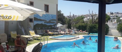 Een seizoensgebonden buitenzwembad, parasols voor strand/zwembad
