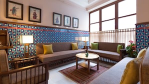 A modern living room with a patterned wall, a sofa set, a coffee table, and a large window. - Lalahan (Istanbul)