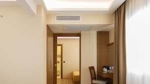 A hotel room with a bed, a desk, a chair, and a bathroom visible through an open door. - Lalahan (Istanbul)