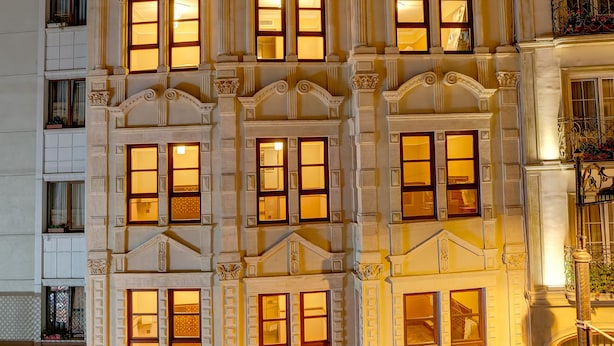 A multi-story building with ornate architectural details, large windows, and a balcony with potted plants. - Lalahan (Istanbul)