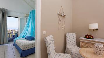Een hotelkamer met een bed, twee stoelen, een tafeltje met een lamp en een decoratie aan de muur.