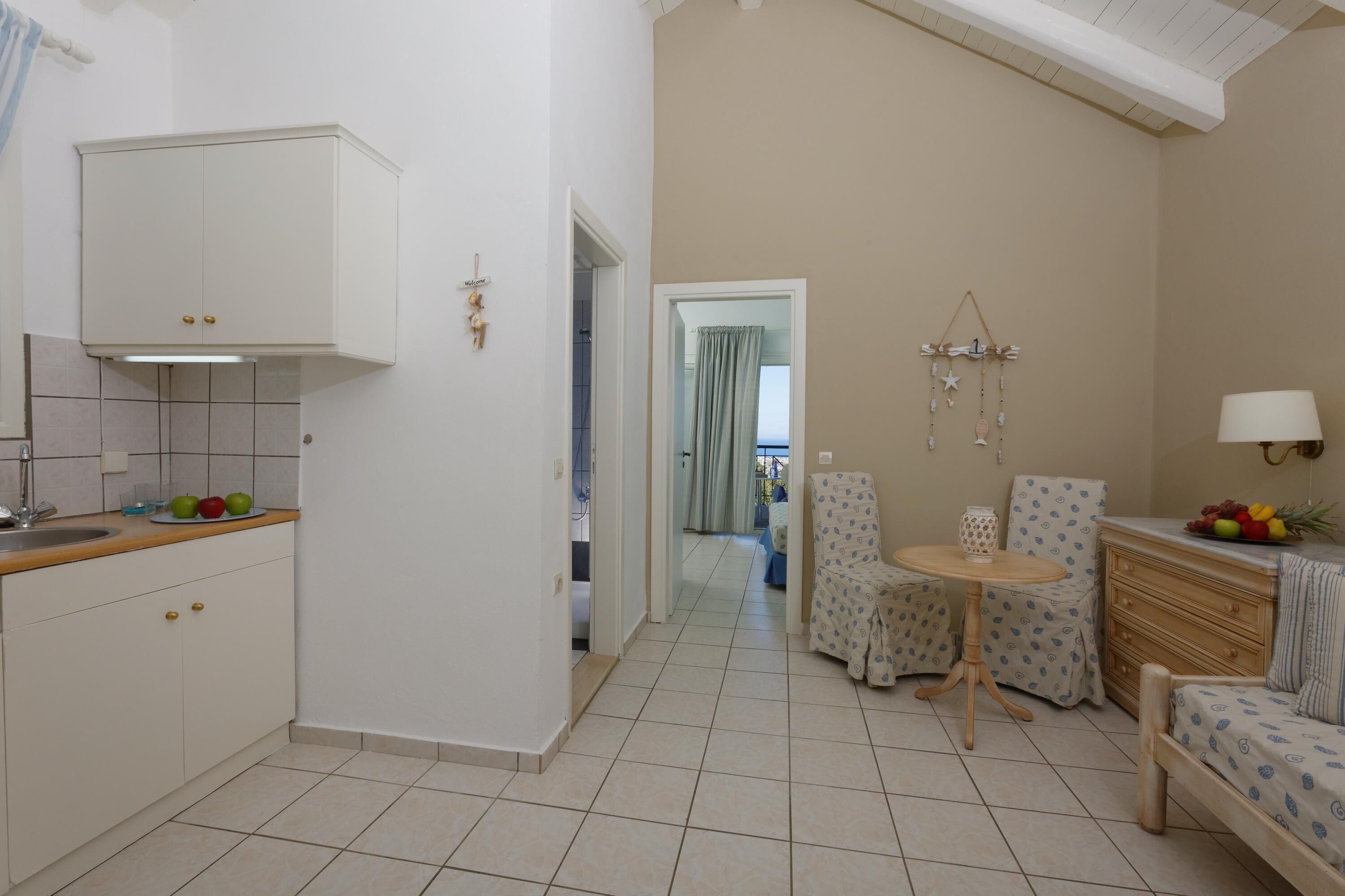 A compact living space with a kitchenette, a dining area, and a small seating area.