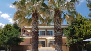 A modern building with a pool, two palm trees, and a staircase leading to the entrance. - Luxurious Villa Anna Maria (Kassandra)