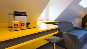 A modern kitchen with a yellow countertop, a coffee machine, and two cups labeled "Buggy's Hot Stuff". - Buddy Hotel (Munich)