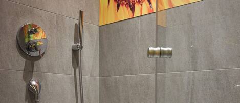 A modern shower enclosure with a handheld showerhead and a fixed showerhead.