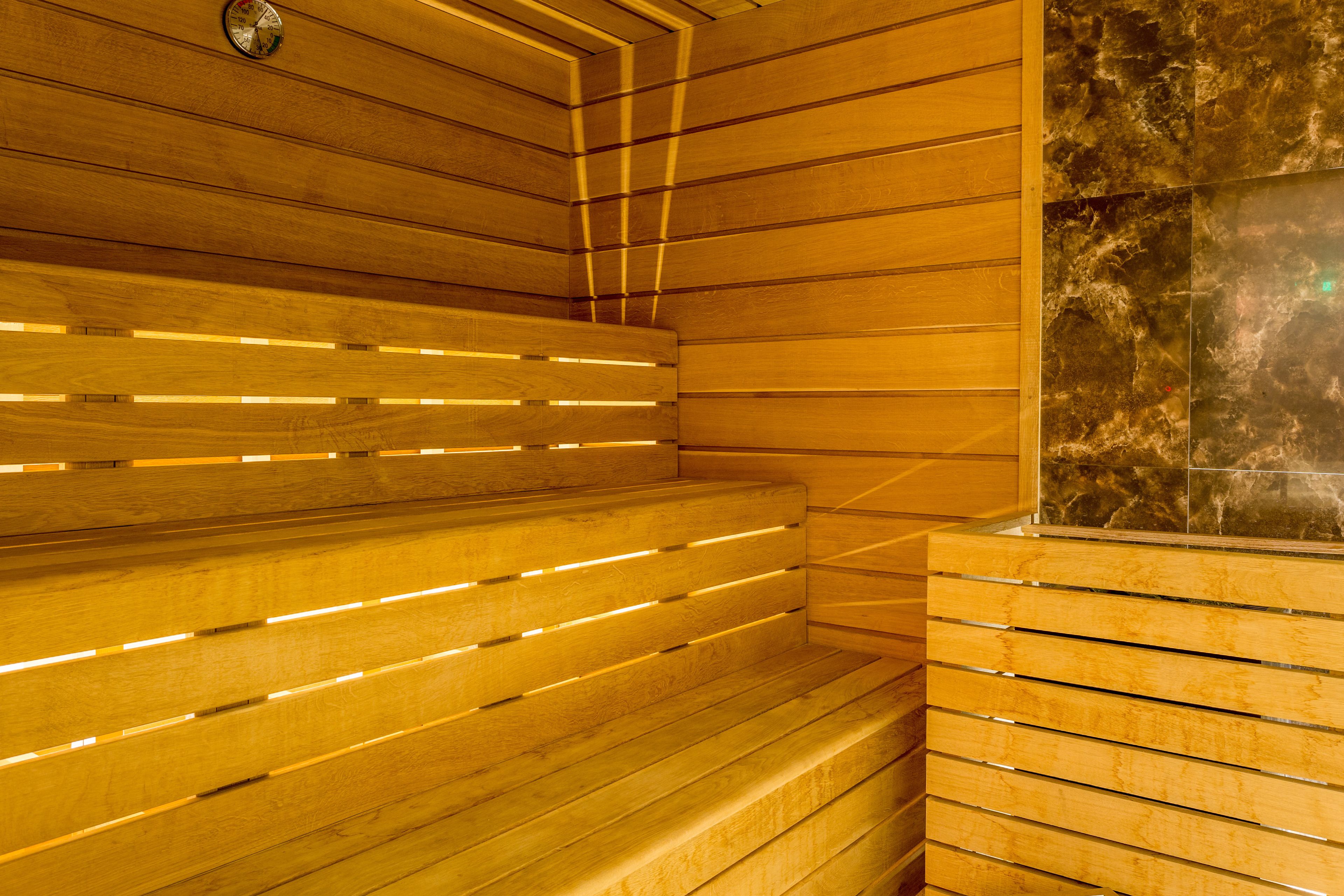 Uma sauna com bancos de madeira e parede de pedra.