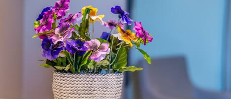 Una planta en maceta con diversas flores sobre una mesa.