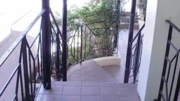 A covered outdoor staircase with black railings leading to a building entrance.