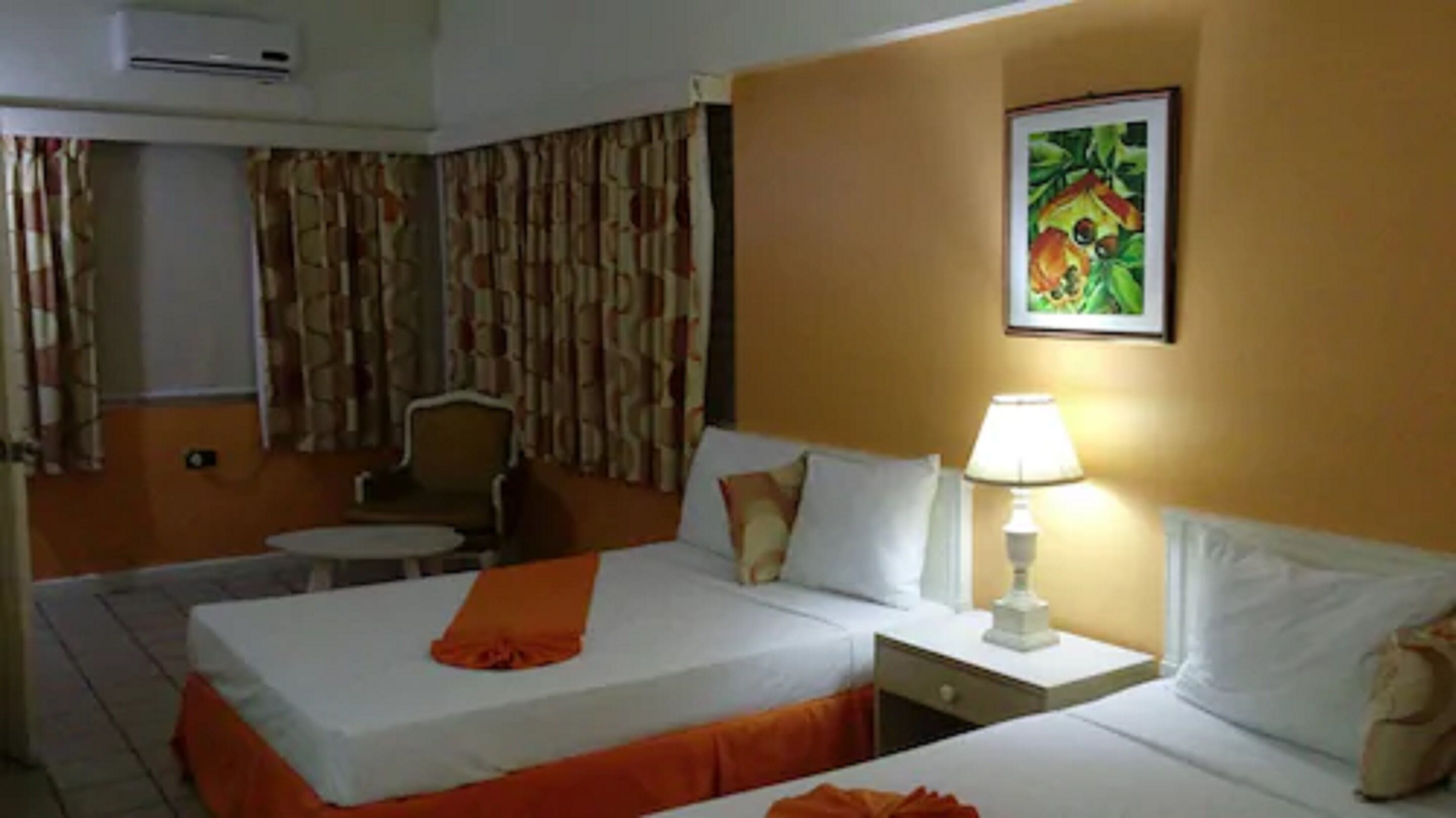 Una habitación de hotel con una cama, una silla, una mesa y una lámpara.