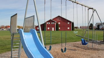 Children can play on the playground with a slide and swings.