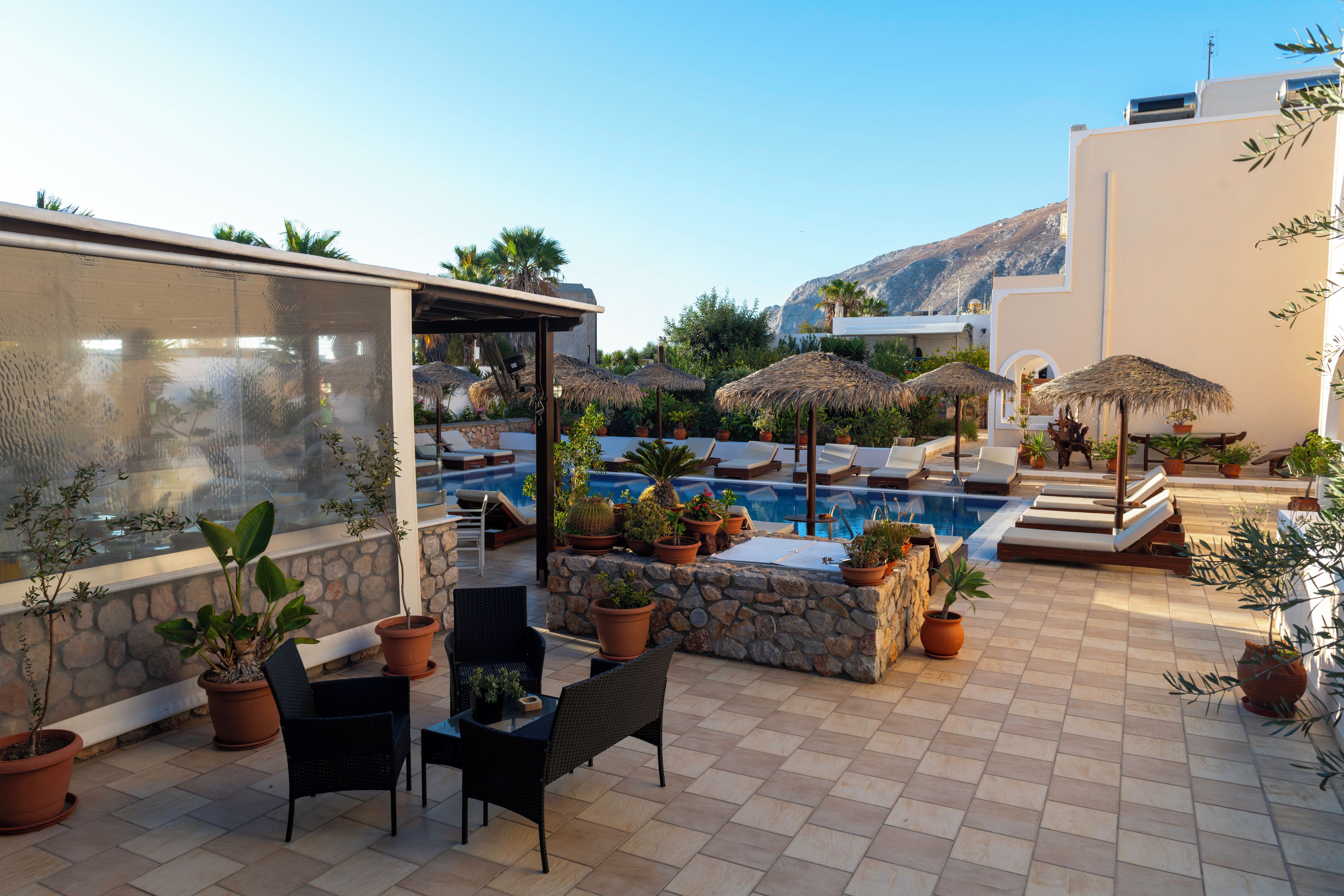 A poolside area with lounge chairs, potted plants, and a clear view of the pool.