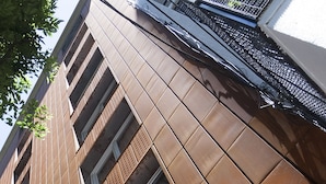 Fachada moderna de un edificio con un letrero que dice "ARENA HOSPITALS".