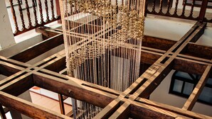 A multi-level wooden staircase with a decorative hanging structure.