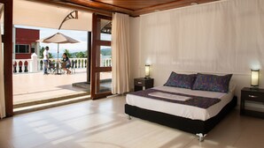 A hotel room with a bed, nightstands, and a view of the outdoor patio area.