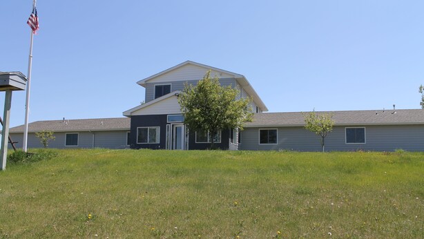 A two-story building with a flat roof and a central entrance.