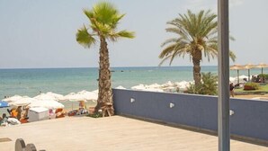 A covered outdoor seating area with a view of the beach and ocean. - Stalis Hotel (Hersonissos)