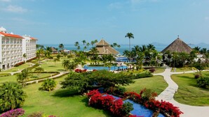 A resort with a pool, palm trees, and a building with a red roof. - Dreams Playa Bonita Panama - All Inclusive (Veracruz)
