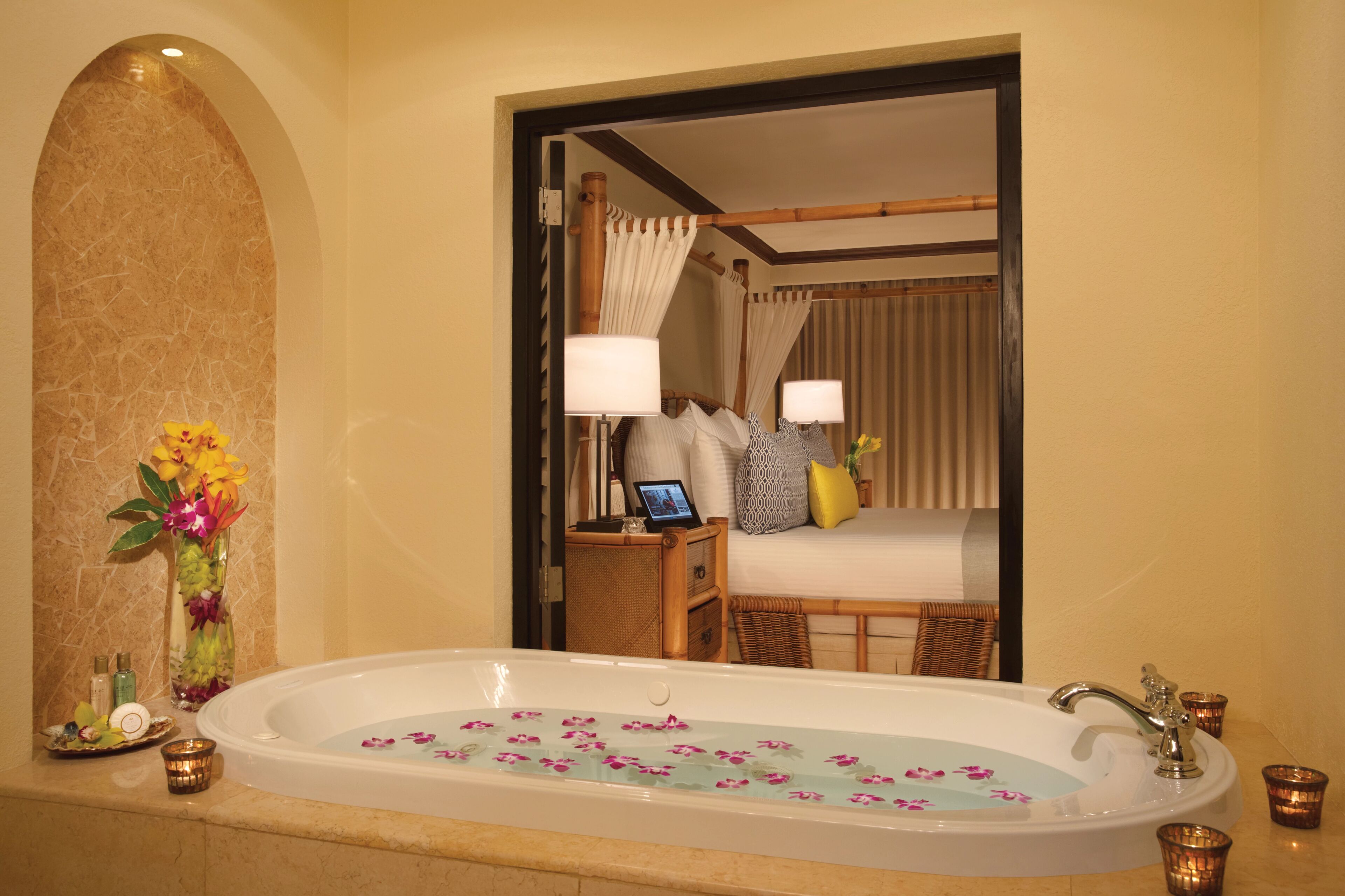 A bathroom with a bathtub, a mirror, and a vanity with toiletries.