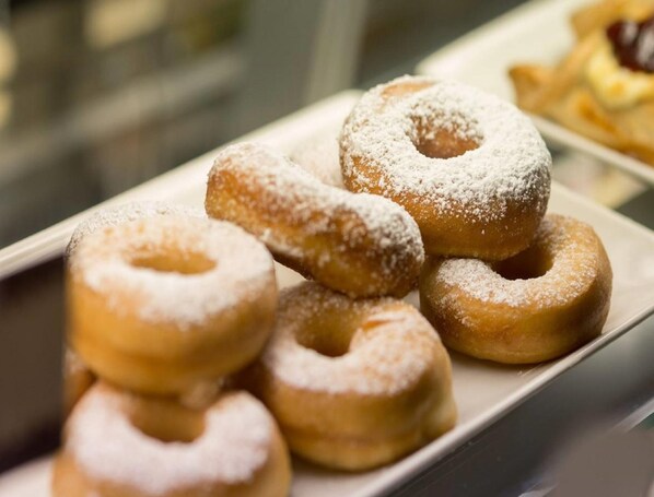 A display of glazed doughnuts with powdered sugar.