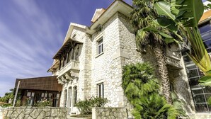 A stone building with a modern design, featuring a stone facade, large windows, and a staircase leading to the entrance. - The Boutique Hotel Solar Palmeiras (Oeiras)