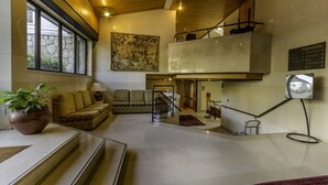 A spacious living area with a sofa, a coffee table, and a potted plant. - The Boutique Hotel Solar Palmeiras (Oeiras)