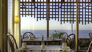A dining area with a table set for two, overlooking the sea. - The Boutique Hotel Solar Palmeiras (Oeiras)