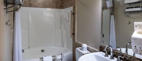 A modern bathroom with a bathtub, toilet, and sink.