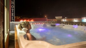 Un jacuzzi con vista a un edificio de hotel al fondo.