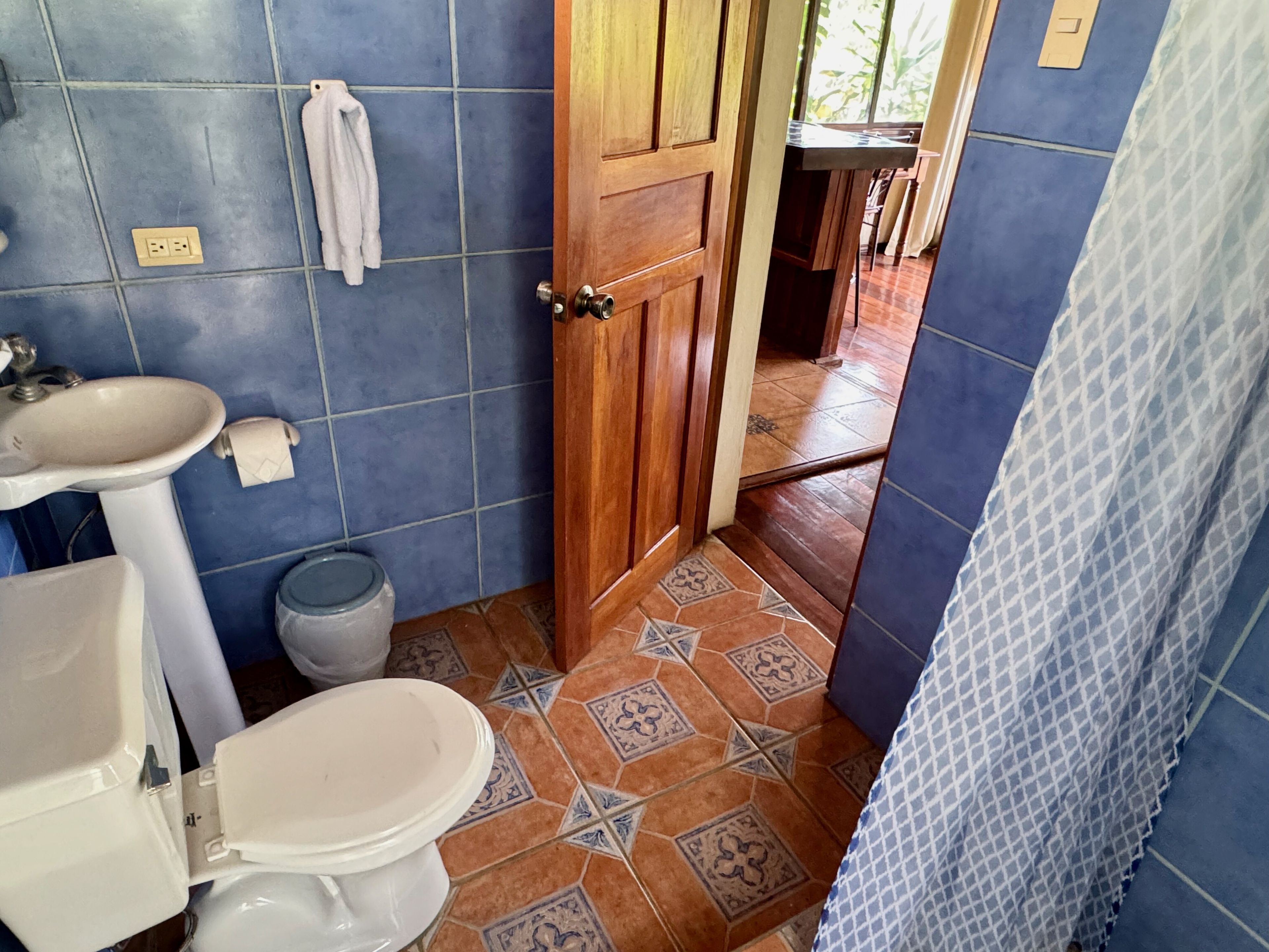 Un baño con inodoro, lavamanos y cortina de ducha.