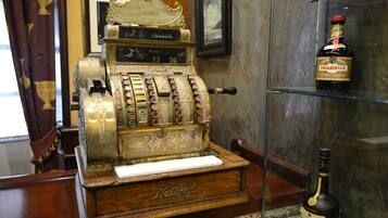 An antique slot machine with a display showing 'PAGADO' and 'Pesos 103 50'.